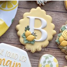 decorated cookies with the letter b and lemons are on a table next to plates