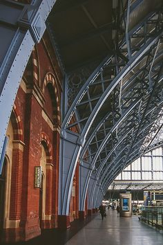 the inside of a train station with people walking around