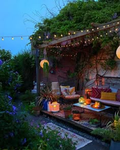 an outdoor seating area is lit up with candles and lanterns for the night time atmosphere