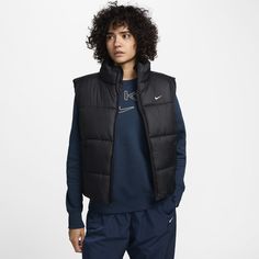 Take on the winter chill in a vest designed to add some warmth to your life. Loose enough to layer, its synthetic fill adds insulation while Nike Therma-FIT technology helps manage your body’s natural heat to help keep you warm in cold-weather conditions. On top of that, a water-repellent finish helps keep you dry. So zip it up, throw your hands in the pockets and get out there! Loose Vest, Womens Puffer Vest, Nike Classic, Vest Designs, Outerwear Vest, Women Lifestyle, Christmas 2024, Puffer Vest, Outerwear Women