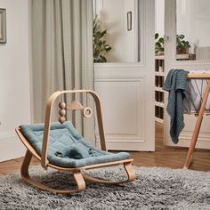 a rocking chair in a living room next to a baby crib