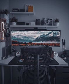 a computer desk with a monitor and keyboard on it in front of a wall mounted television