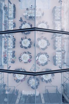 an aerial view of tables and chairs in a glass walled dining room with scaffolding