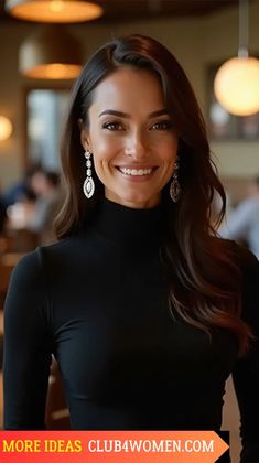 a smiling woman in a black top and earrings