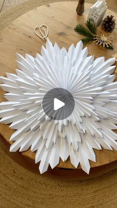 a white paper flower sitting on top of a wooden table