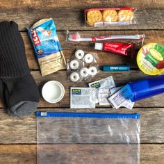 the contents of a travel bag laid out on a wooden table, including toiletries and other items