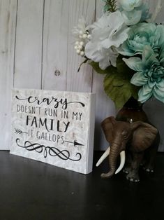 an elephant statue next to a sign that says sorry doesn't run in my family it gallops