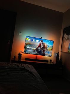 a flat screen tv sitting on top of a wooden stand next to a bed in a bedroom