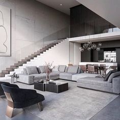 a modern living room with stairs leading up to the second floor and an open concept dining area