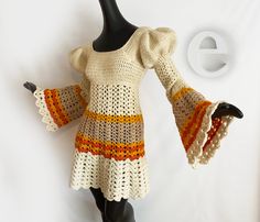 a crocheted dress is displayed on a mannequin