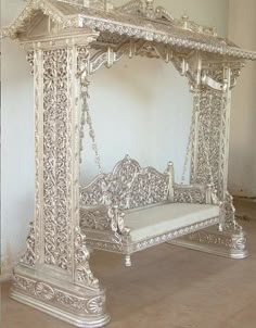 an ornate white bed frame in the middle of a room