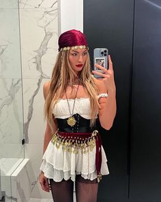 a woman taking a selfie in front of a mirror wearing a costume and headpiece