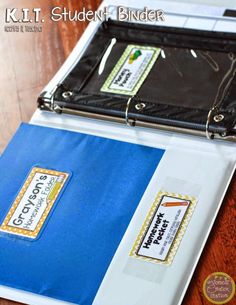 a binder with two folders attached to it on top of a wooden table