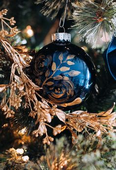 an ornament hanging from a christmas tree with gold and blue ornaments on it