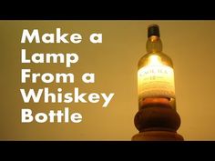 a bottle that is sitting on top of a wooden pole with the words make a lamp from a whiskey bottle