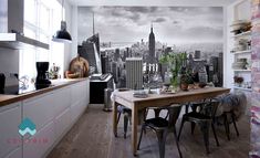 a kitchen with a table and chairs in front of a cityscape wall mural