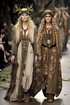 two women walking down a runway with deer antlers on their heads and long hair