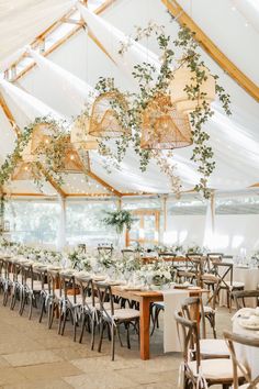 the inside of a tent with tables and chairs set up for an elegant wedding reception