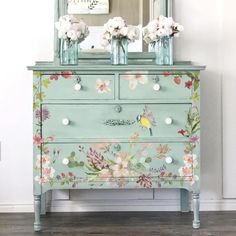 an old dresser painted with flowers and birds on the drawers is shown in this image