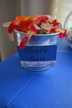 a can filled with gummy bears sitting on top of a blue table