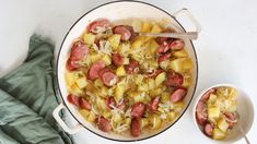 a pot filled with pasta and sausage next to a bowl full of vegetables on top of a white table