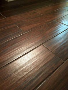 a wooden floor that has been cleaned and is in the process of being polished with dark wood