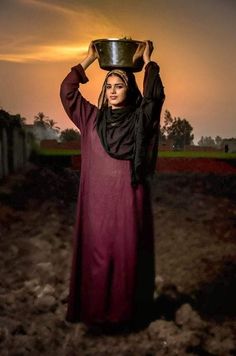 a woman holding a bowl on her head