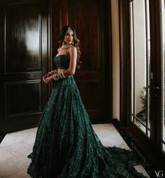 a woman in a green dress standing by a door