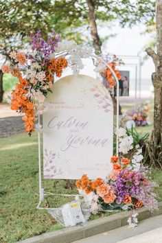 a sign with flowers on it sitting in the grass