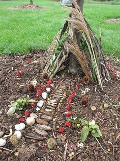 a small wooden structure sitting in the middle of a garden with flowers and plants growing out of it