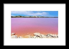 a pink lake with rocks in the foreground