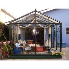 a small green house sitting in the middle of a yard