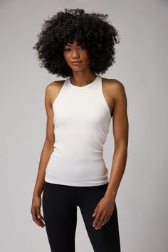 Sleek and slim. A regular to mid-length, slim fit tank with built-in shelf bra and racerback cut. Constructed in a flattering, thick-ribbed Modal Spandex blend material. | Slim Rib Tank Top in Stone Fitted Athleisure Tank Top With Built-in Bra, Sleeveless Elastane Tank Top For Pilates, Versatile Fitted Racerback Activewear, Fitted Racerback Tank Top For Pilates, Ribbed Stretch Racerback Activewear, Versatile Fitted Tank Top For Workout, White Fitted Ribbed Activewear, White High Stretch Ribbed Tank Top, Ribbed Fitted Gym Top