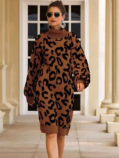 a model walks down the runway in a brown and black leopard print sweater dress with matching sunglasses