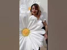 a woman holding two large white flowers in her hands