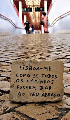 a stone sign sitting on top of a cobblestone floor next to a staircase