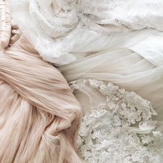 there are many different types of wedding dresses on the bed, including one in white