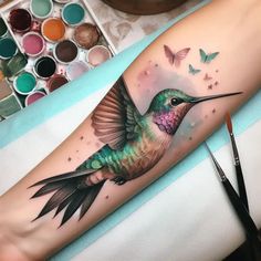 a colorful hummingbird tattoo on the arm