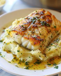 a white plate topped with chicken and potatoes covered in grated parmesan cheese