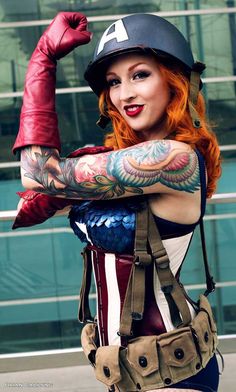 a woman with red hair and tattoos is posing for the camera while wearing an american flag outfit