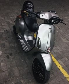 a motor scooter parked on the side of a road next to a yellow line