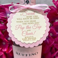 a bottle of wine with a pink bow on it's neck and label that says, sweet baby girl when you hear pop the top and cheer