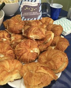 there are many croissants on the table with a sign in front of them