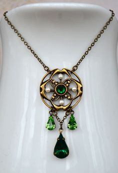 "VINTAGE ELEMENTS Unique Jewellery, Handmade from Vintage Inspired , Original Designs Edwardian, Victorian, Art Nouveau, Art Deco style antiqued Brass Necklace with Emerald and Peridot Green glass drops. This necklace has a fine, elegant, antiqued brass chain and measures 17 1/4\" (44cm) from end to end with a 2 1/2\" (6cm) extender chain." Vintage Baroque Jewelry With Historical Design, Vintage Filigree Baroque Necklace, Green Brass Jewelry With Vintage Charm, Green Vintage Charm Brass Jewelry, Vintage Pendant Necklace With Historical Design, Antique Green Jewelry With Vintage Charm, Vintage Brass Jewelry With Historical Design, Green Victorian Necklace For Wedding, Antique Green Jeweled Necklace