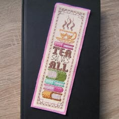 a cross stitch bookmark that says tea solves all