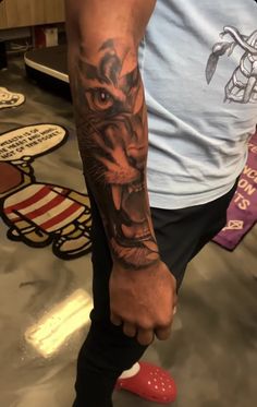 a man's arm with a tiger tattoo on it and a red shoe in the foreground