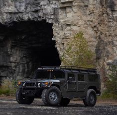 a jeep is parked in front of a cave