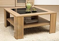 a coffee table with a glass top and wooden legs on carpeted flooring in front of cabinets