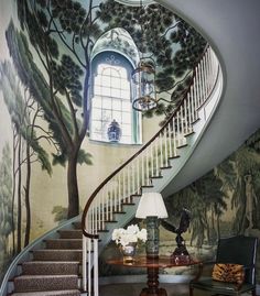 the stairs in this house are painted with trees and flowers on them, as well as an arched window