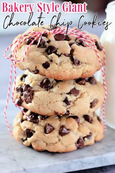 three chocolate chip cookies stacked on top of each other next to a glass of milk